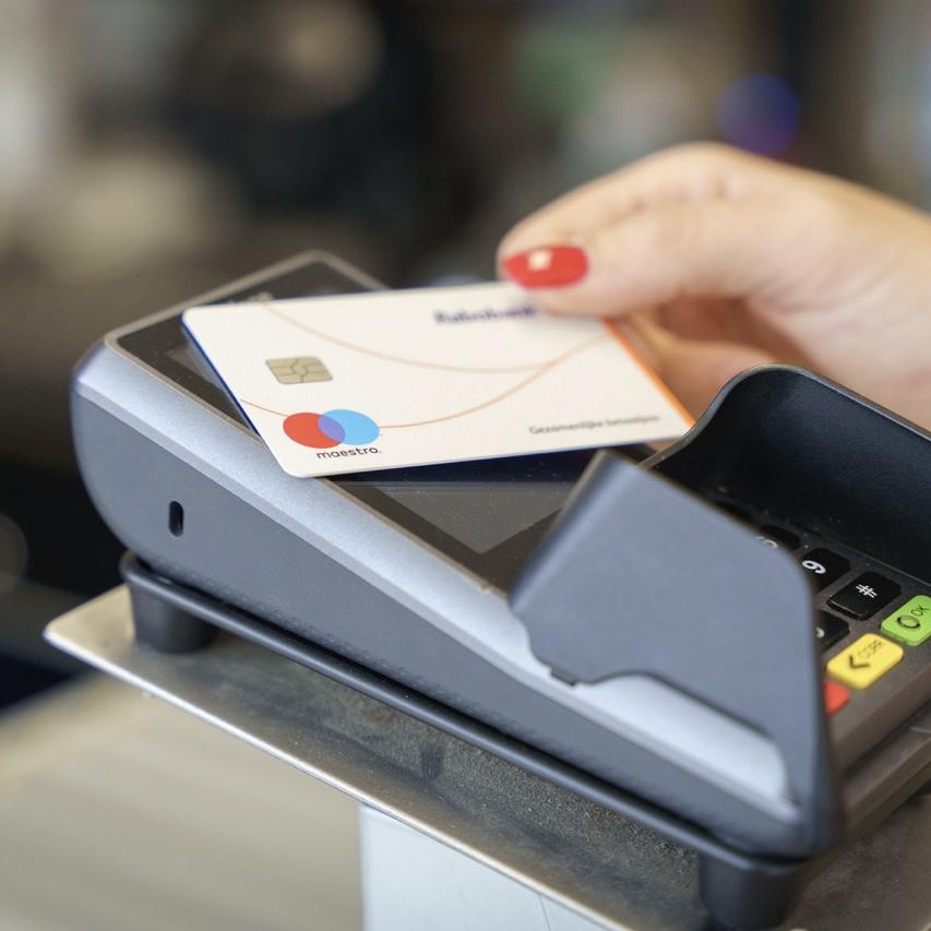 Hand scant pinpas op een mobiel betaalapparaat.